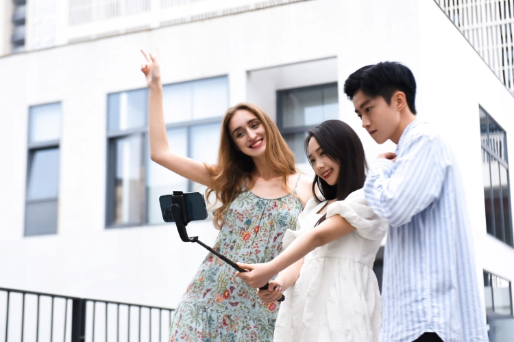 Gimbal Hohem iSteady Q czarny w użyciu – wspólne selfie trojga znajomych w mieście