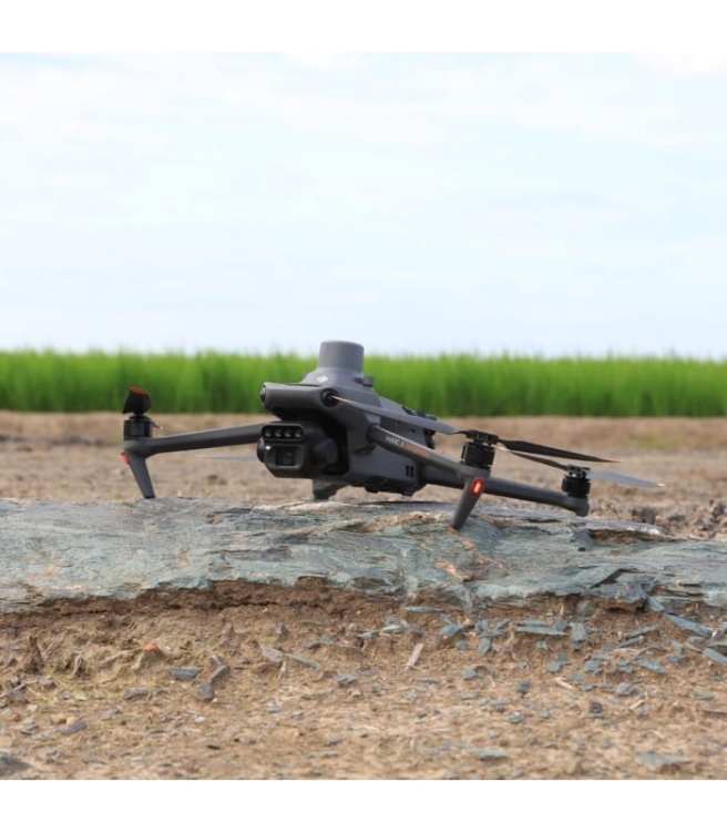 DJI Mavic 3M stojący na ziemi przy polu uprawnym