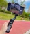 Gimbal Hohem iSteady X2 czarny w dłoni ze smartfonem podczas spaceru w mieście