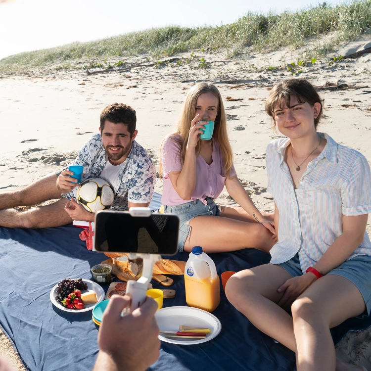 Gimbal Hohem iSteady X w użyciu – znajomi na pikniku na plaży nagrywani smartfonem