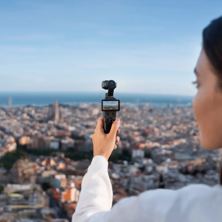 Kobieta filmuje panoramę miasta kamerą DJI Osmo Pocket 4 trzymaną w dłoni