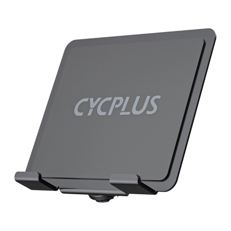 Kierownica roweru stacjonarnego z zamontowanym uchwytem Cycplus na duży tablet podczas treningu w pomieszczeniu.