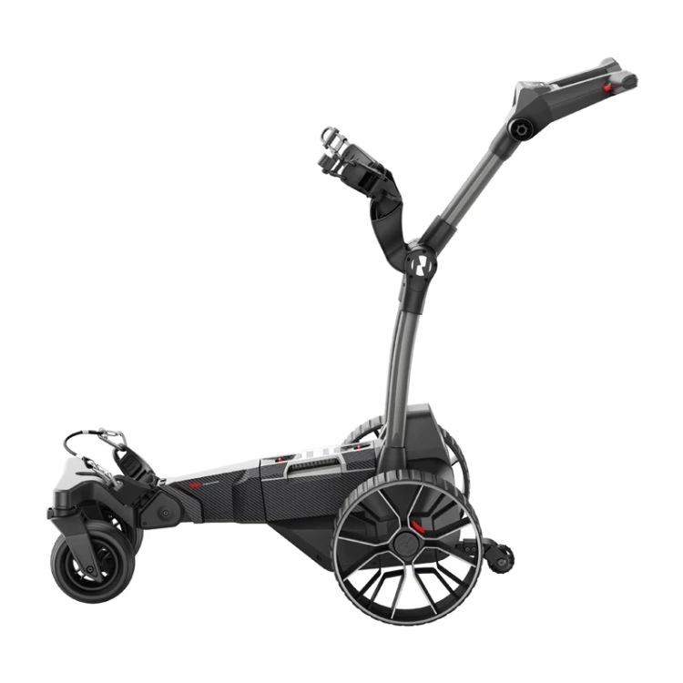Golfista idzie pod górę za elektrycznym wózkiem golfowym przewożącym torbę z kijami.
