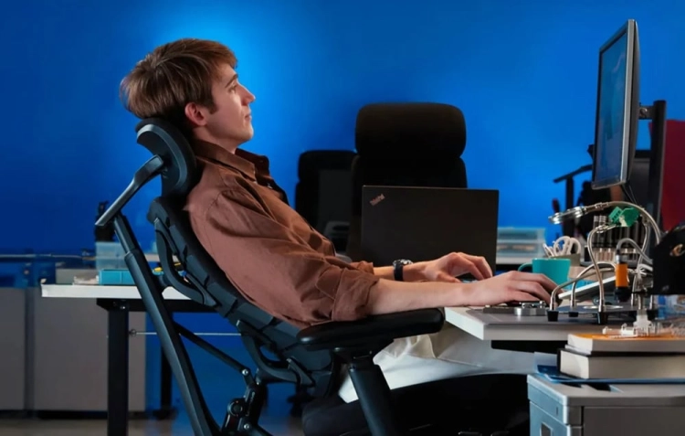 Użytkownik odpoczywający na odchylonym czarnym krześle ergonomicznym LiberNovo Omni SE
