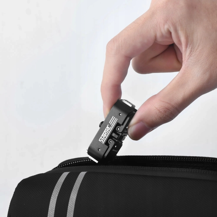 Dłoń trzymająca magnetyczną szybkozłączkę STARTRC do GoPro HERO 13 z paskiem transportowym