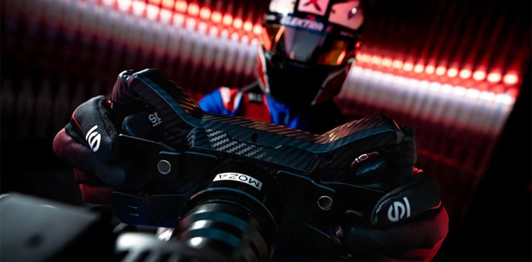 Mężczyzna w kasku trzymający kierownicę MOZA Racing KS do symulatorów F1 i GT