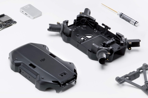 Części drona DJI Enterprise wymieniane w serwisie – osłona, rama, element podwozia i śrubokręt