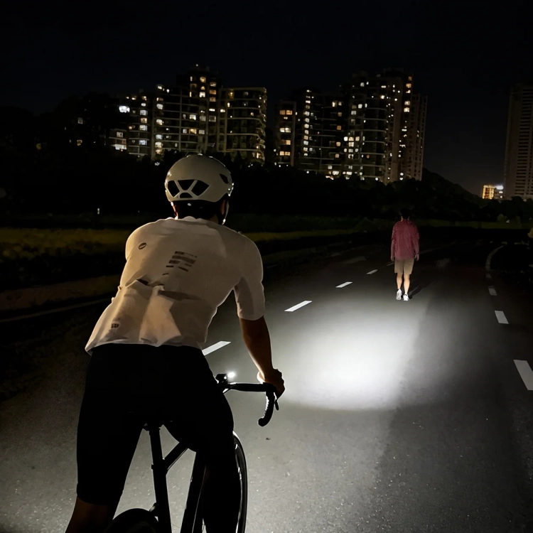 Rowerzysta nocą na drodze oświetlonej przednią lampką CYCLAMI BR-500