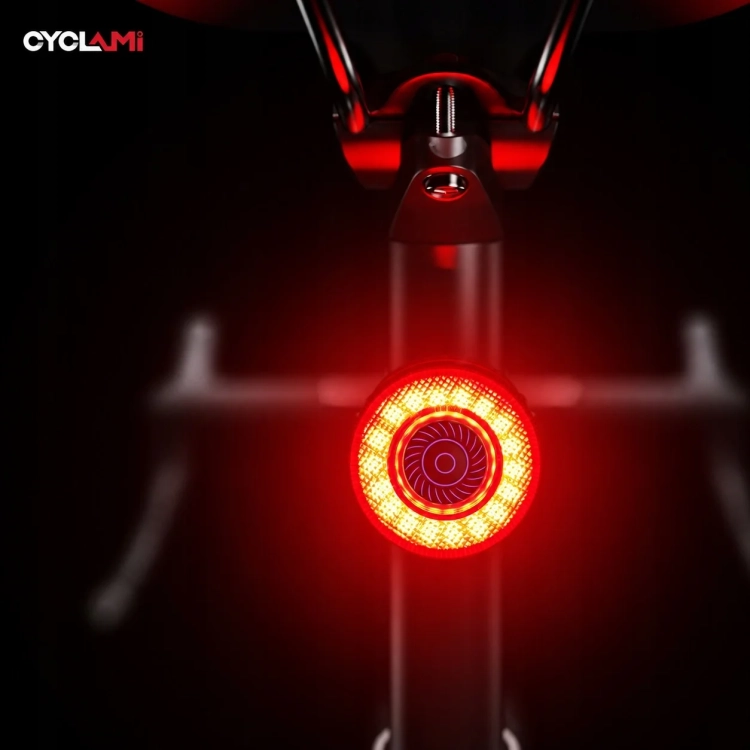 Włączona lampka CYCLAMI CY120 nocą, widok z tyłu roweru
