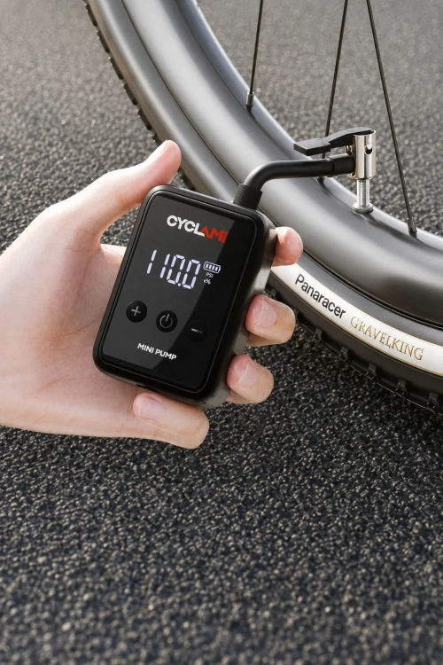 Pompka CYCLAMI HW-125 w dłoni podłączona do wentyla koła