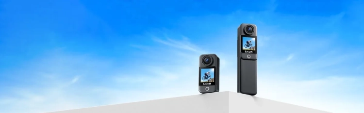 Kamery SJCAM C300 Pocket i C300 z uchwytem z akumulatorem obok siebie na tle nieba