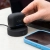 Etui JLab JBuds Pods ANC na ładowarce bezprzewodowej obok telefonu