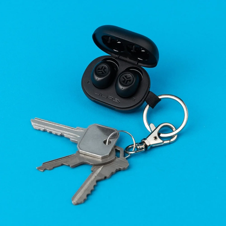 Etui JLab JBuds Mini przypięte do kluczy na niebieskim tle