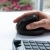 Dłoń na pionowej myszy JLab JBuds Ergonomic obok klawiatury