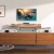 Zestaw Ultimea Poseidon D50 na komodzie pod telewizorem, subwoofer obok na podłodze