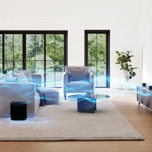 Ultimea Poseidon D70 w salonie, głośniki surround przy fotelu i subwoofer na dywanie