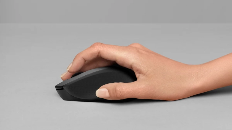 Dłoń prowadząca czarną mysz Logitech M280 po biurku