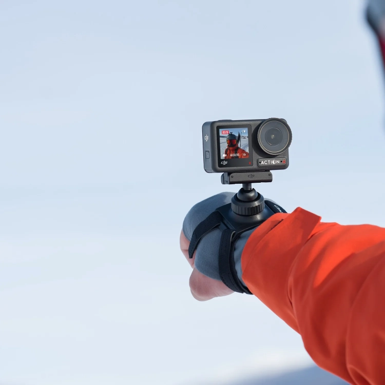 Kamera DJI Osmo Action na nadgarstku narciarza w mocowaniu 360° Wrist Strap