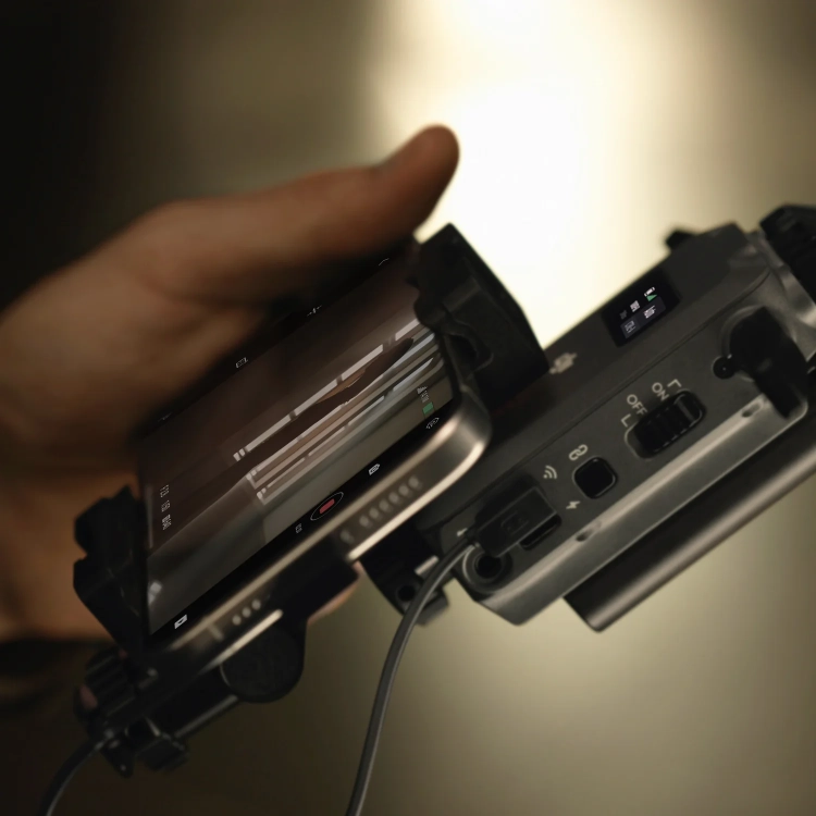 Odbiornik DJI SDR Transmission połączony kablem USB-C z telefonem w dłoni operatora