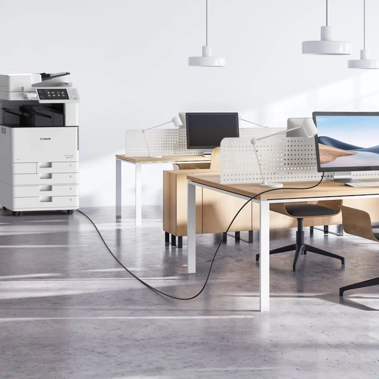 Kabel UGREEN US135 łączy drukarkę biurową z laptopem na sąsiednim biurku