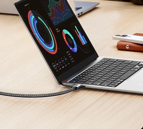 Laptop na stole z wpiętym kablem HDMI UGREEN HD171 w oplocie