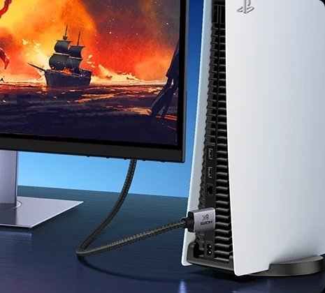 Kabel HDMI UGREEN HD171 wpięty z tyłu konsoli stojącej przy monitorze