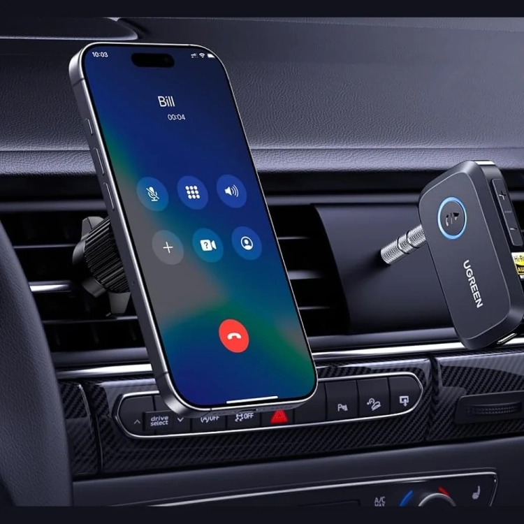 UGREEN BT509 wpięty w gniazdo AUX w samochodzie obok telefonu w uchwycie
