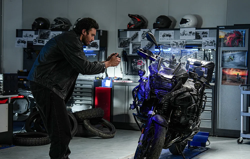 Mężczyzna wykorzystujący ręczny skaner 3D do zmapowania przodu motocykla