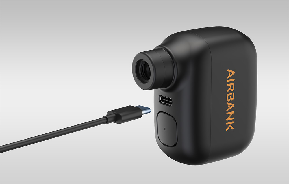 Widok na gniazdo ładowania mini pompki Airbank z przybliżonym kablem zasilającym z wtyczką typu USB-C.