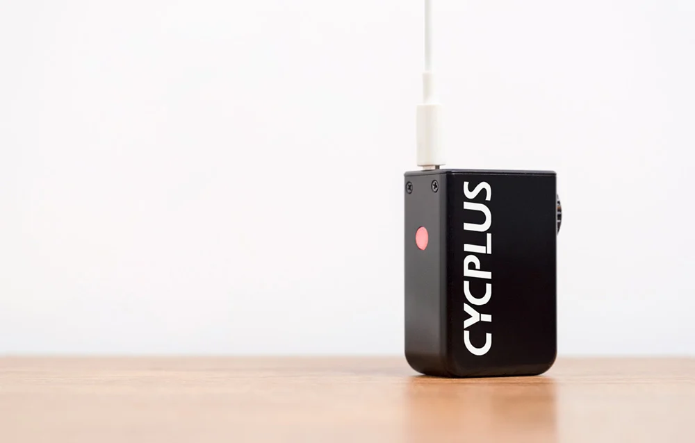 Pompka Cycplus AS2 podłączona przewodem zasilającym USB-C do portu w celu szybkiego naładowania.