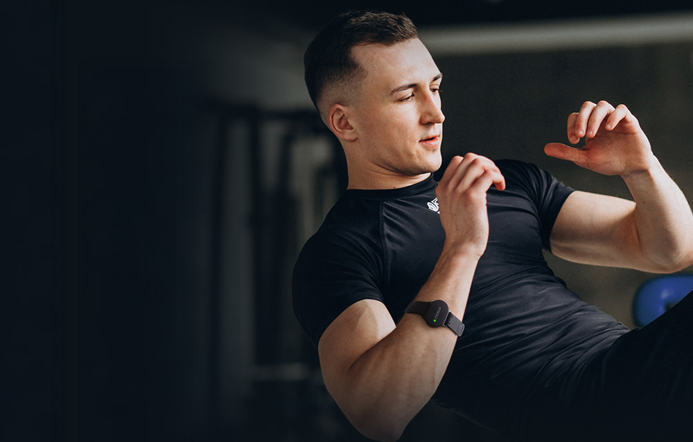 Kobieta w stroju sportowym podczas intensywnego treningu na ciemnym tle, kontrolująca swoje tętno z opaską Cycplus.