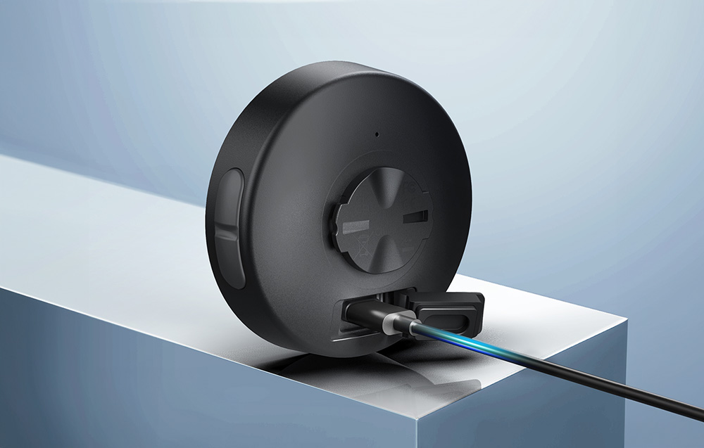 Licznik rowerowy Cycplus M2 podłączony przewodem do ładowania przez nowoczesne złącze USB-C.