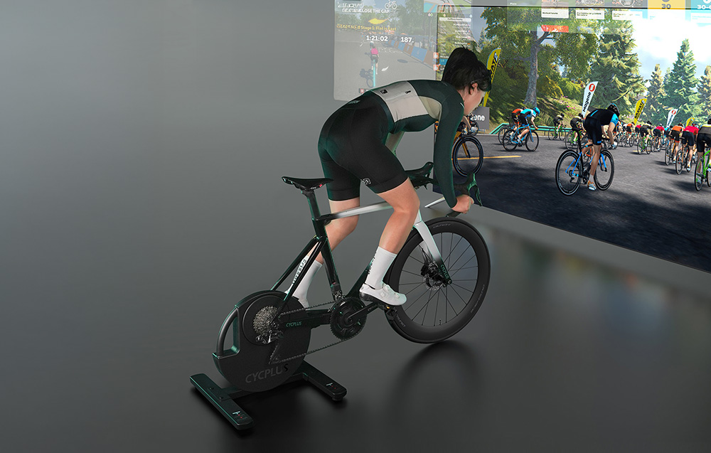 Integracja trenażera Cycplus ze środowiskiem wirtualnym e-sportu wyświetlanym na dużym ekranie.