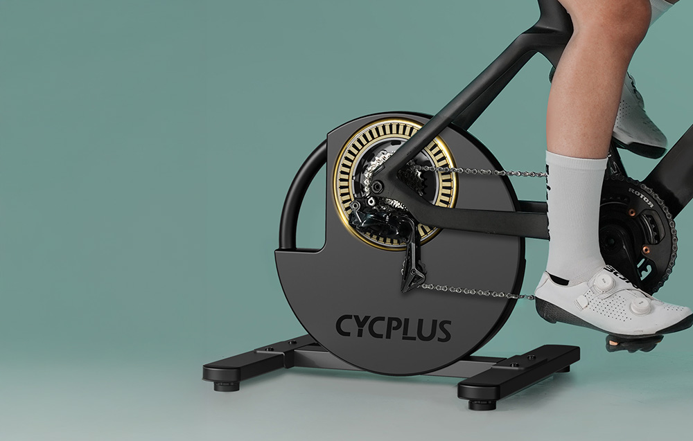 Mężczyzna na trenażerze rowerowym Cycplus podczas generowania wysokiej mocy w pedały.
