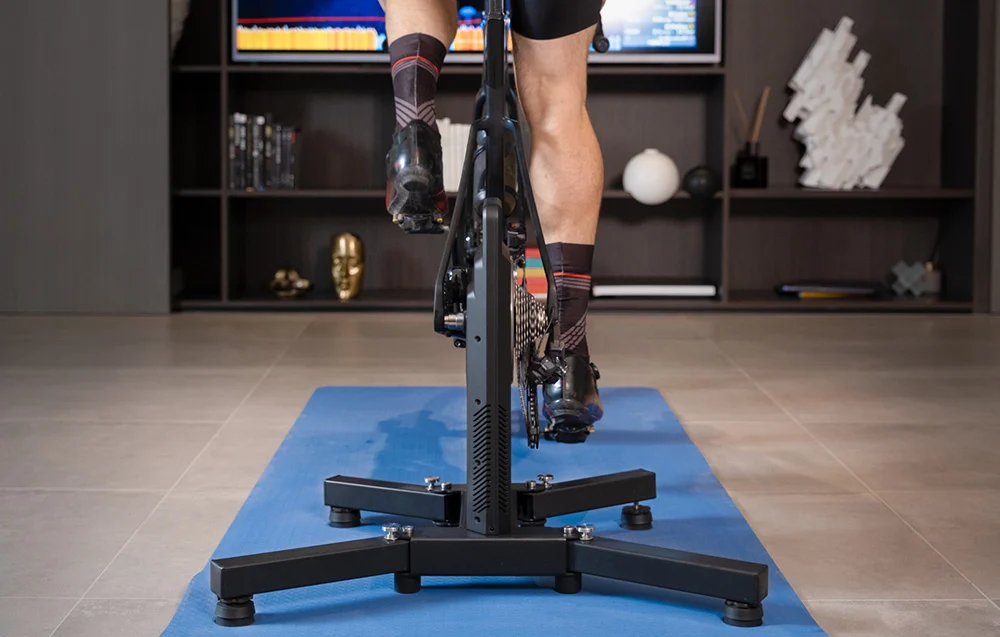 Zbliżenie na pracę tylnego koła roweru spiętego z innowacyjnym napędem bezpasowym trenażera Cycplus T2.