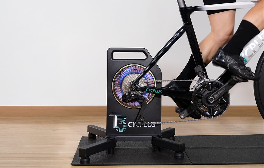 Detaliczna wizualizacja wbudowanego trenażera Cycplus T3 na tylnym kole roweru z widoczną kasetą.