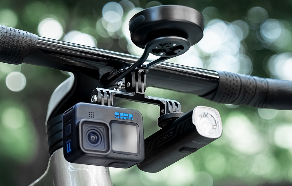Rozbudowany uchwyt Cycplus Z3 na kierownicy utrzymujący komputer, przednią lampkę oraz kamerę sportową.