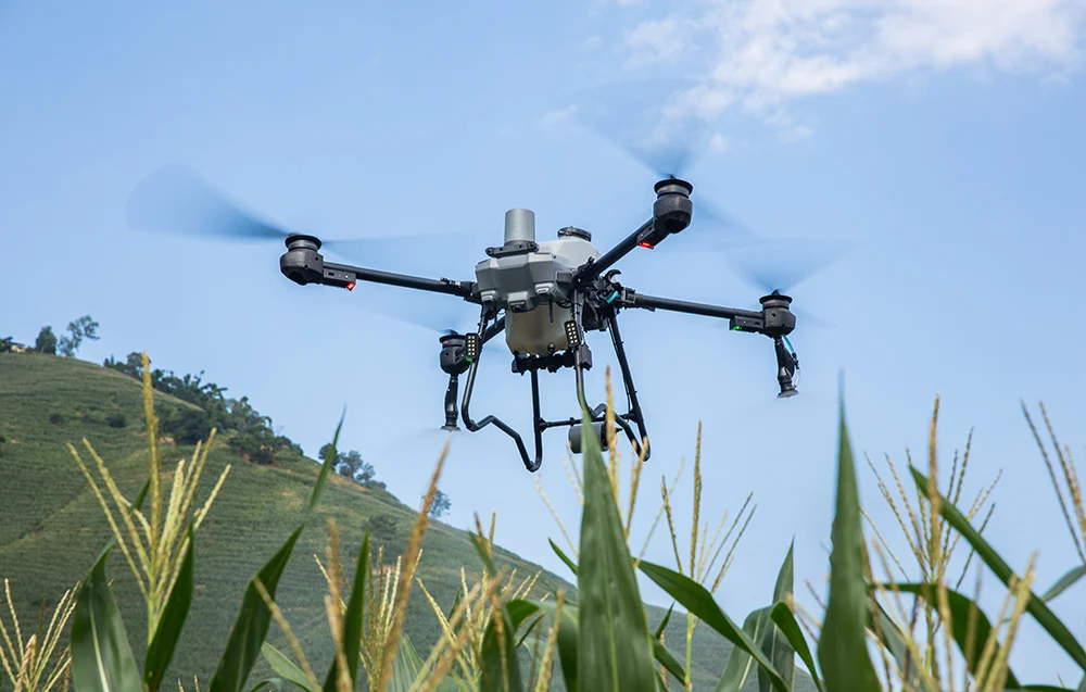 DJI Agras T25P w locie nad polem – kompaktowy dron rolniczy do oprysków i rozsiewu.