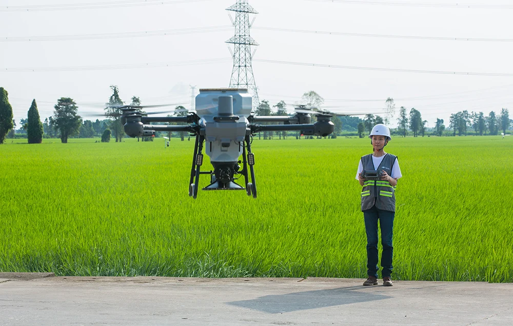 DJI Agras T25P na drodze przy zielonej trawie – bezpieczne przygotowanie do startu i ustawienie sprzętu.