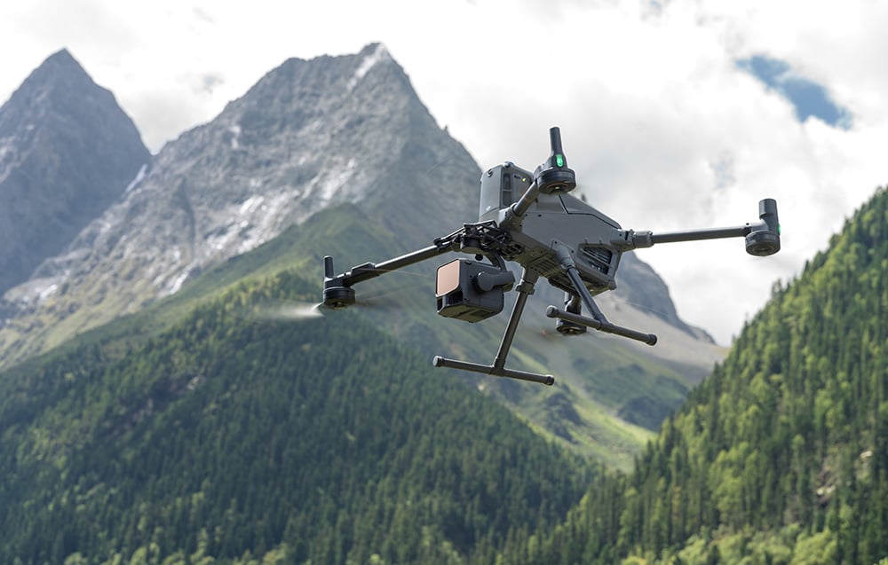 Dron DJI z kamerą Zenmuse L3 w locie nad górskim lasem