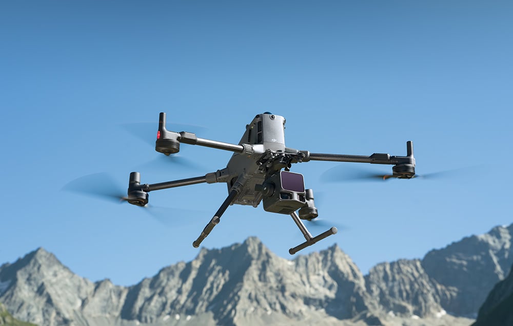 Dron DJI z kamerą Zenmuse L3 w locie nad skalistymi górskimi szczytami