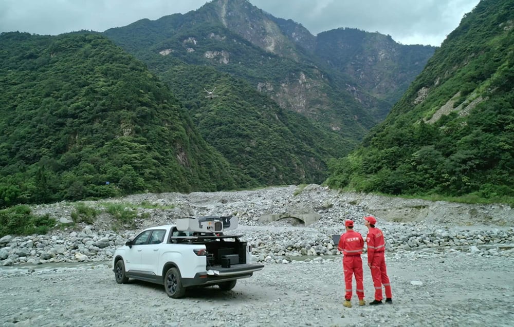 Biały pickup z mobilnym centrum dowodzenia i ekipą ratunkową w górskim terenie