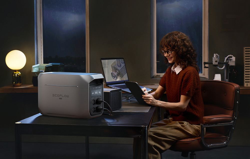Kobieta pracująca przy biurku z tabletem zasilanym awaryjnie przez stację EcoFlow