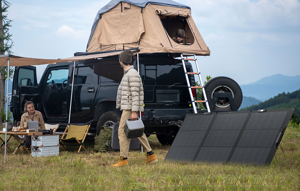 Kemping z kamperem i rozłożonym panelem EcoFlow
