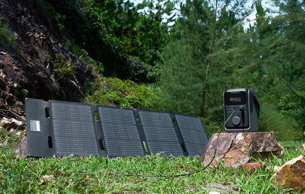 Panel fotowoltaiczny podłączony do stacji EcoFlow TRAIL 300 DC stojącej na kamieniu w lesie