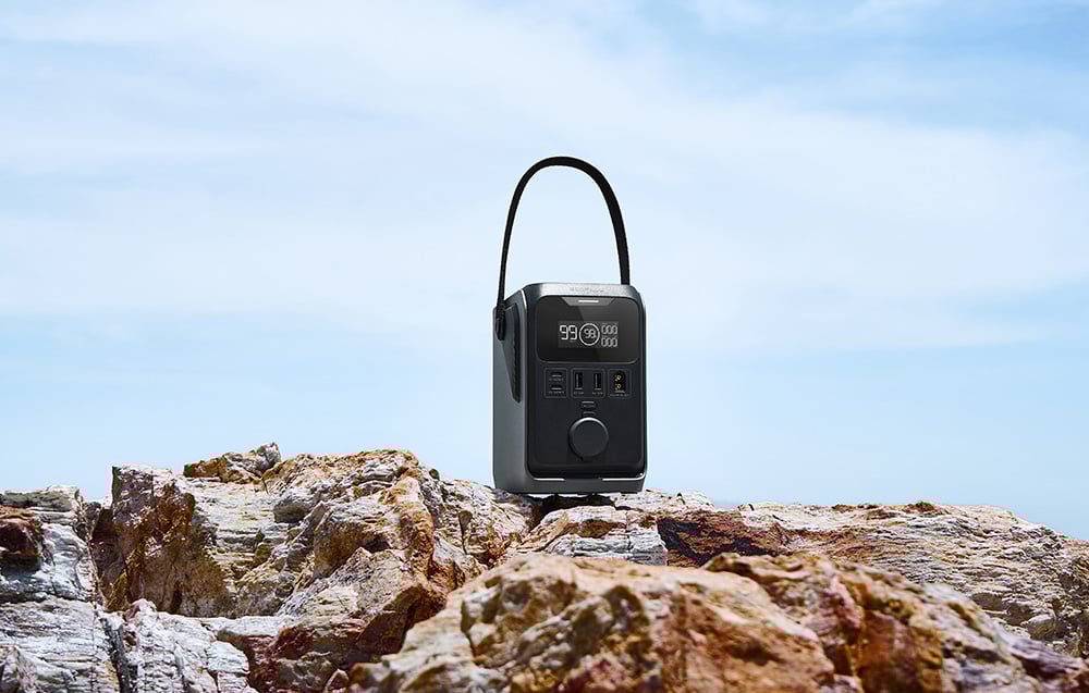 Przenośna stacja zasilania EcoFlow TRAIL 300 DC stojąca na skale nad morzem