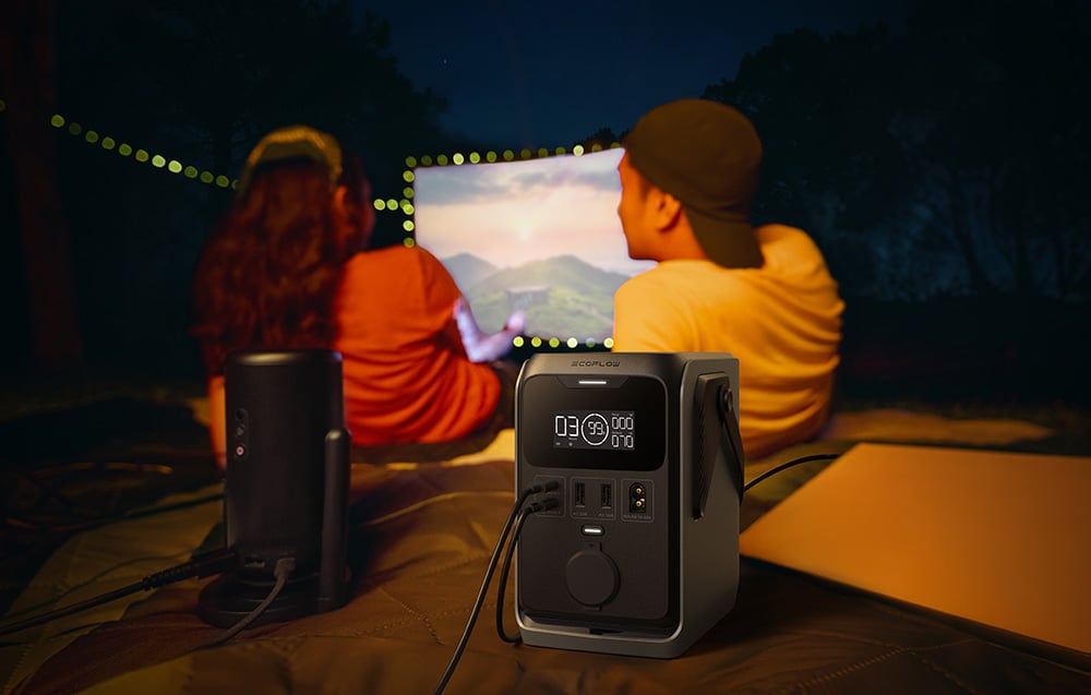 Dwie osoby oglądają film z projektora zasilanego przez stację EcoFlow TRAIL 300 DC