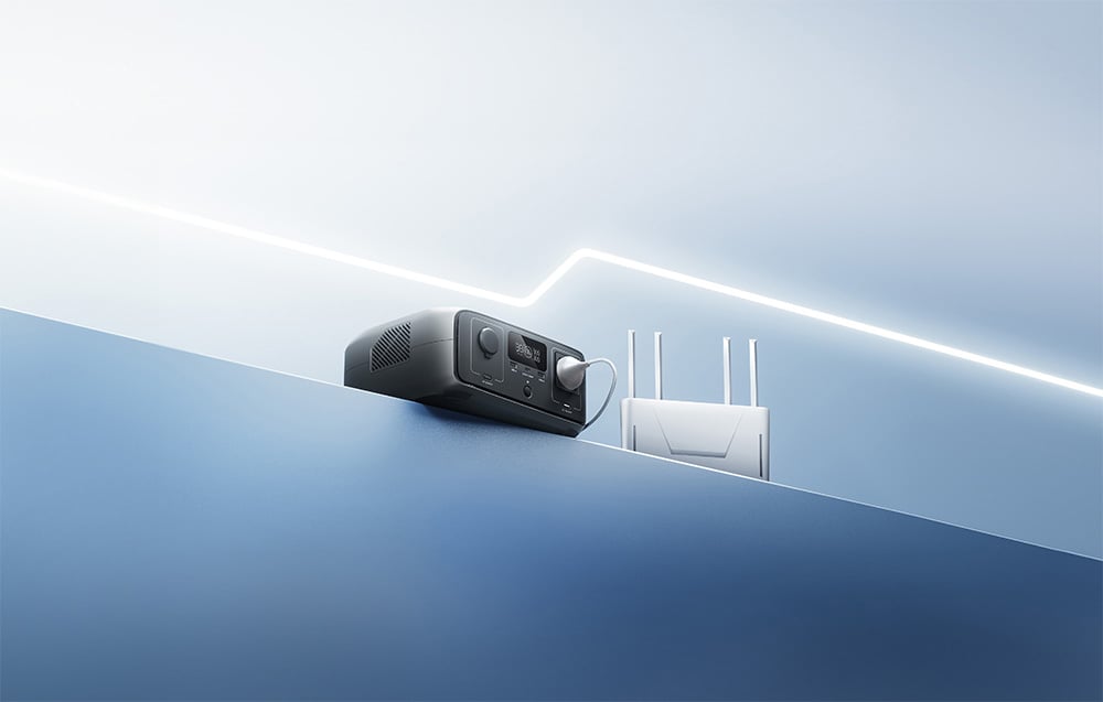 Stacja zasilania EcoFlow RIVER 3 UPS podłączona do routera na minimalistycznym niebieskim blacie