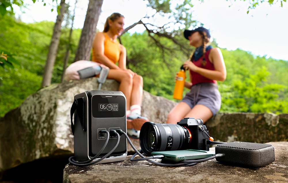 EcoFlow TRAIL 200 DC z podłączonymi urządzeniami na skale w otoczeniu przyrody