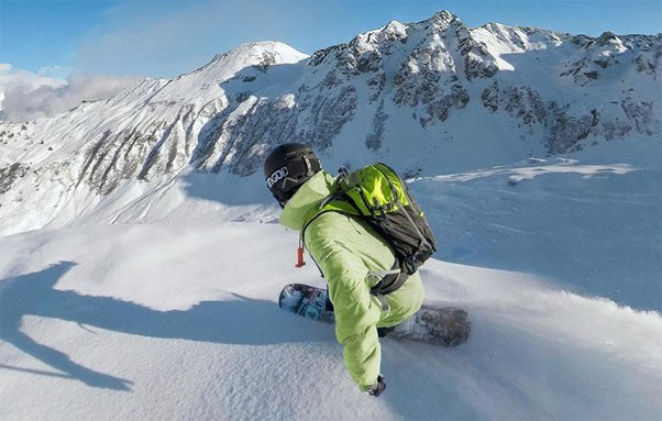 Snowboardzista nagrywający swój zjazd efektem niewidzialnego kijka